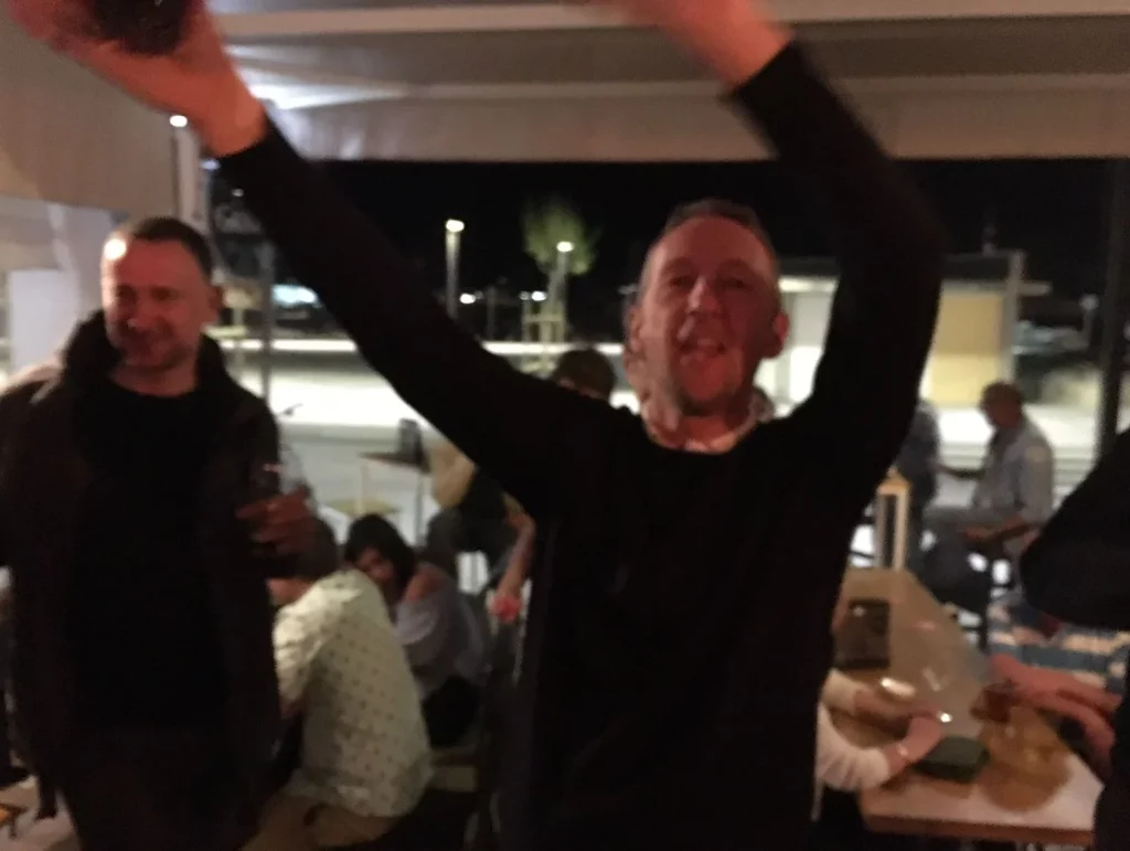 Club member Andrew waving his hands in the air, clearly enjoying the evening in the Tour de Mallorca.