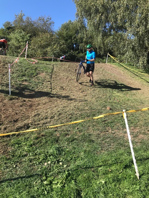 Tom carrying his bike on a steep banked section of the cyclocross race